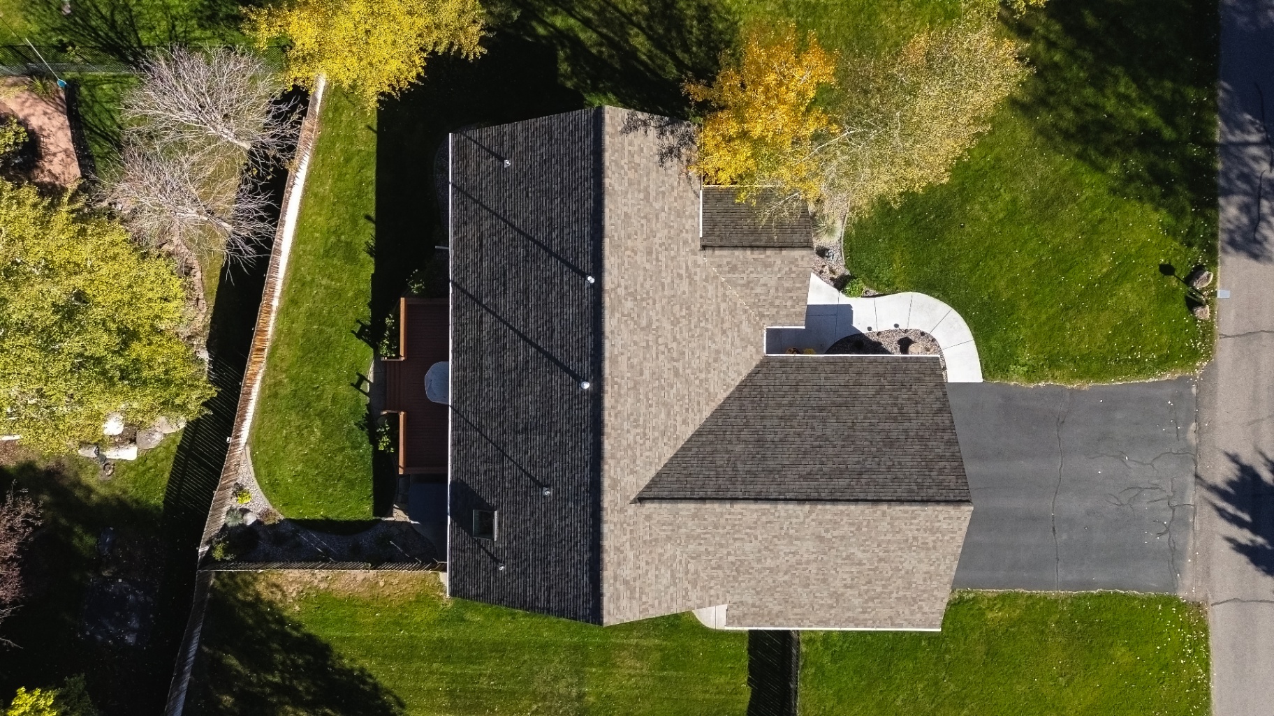 Top-down aerial of completed shingle roof with curved walkway