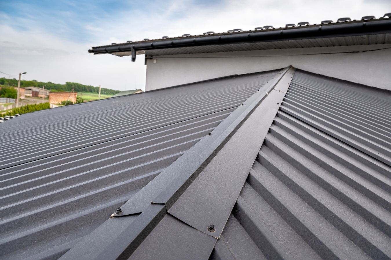 Dark standing-seam metal roof with ridge cap detail