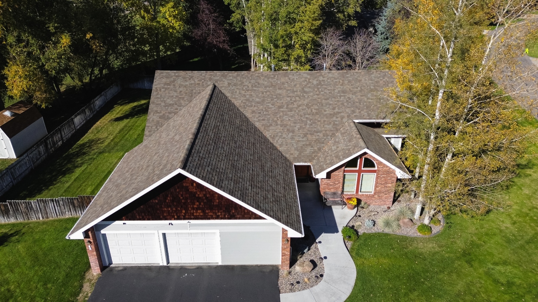Front aerial of brick home with new architectural shingles